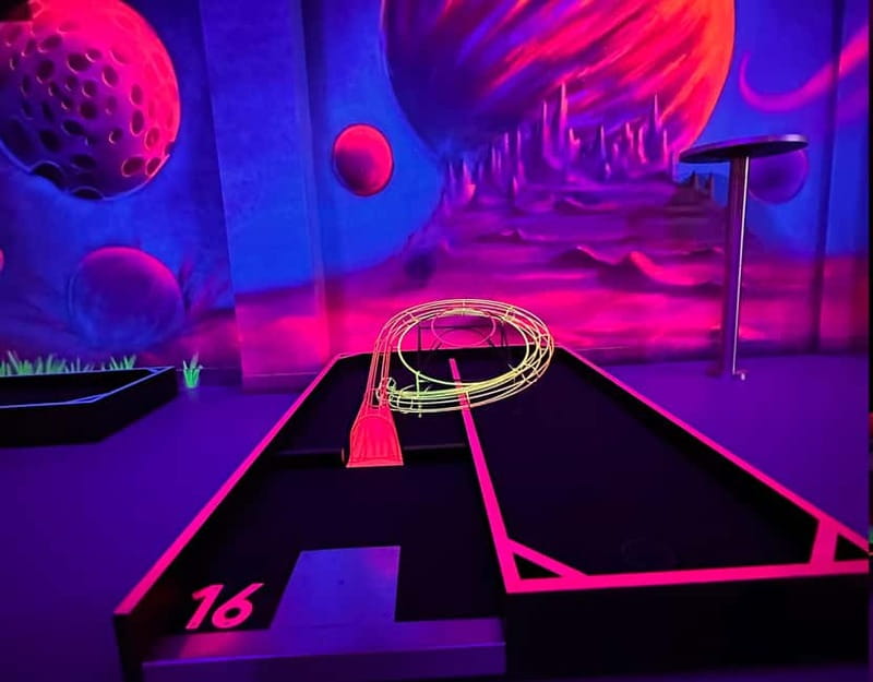 Seville: Indoor UV 18 hole Minigolf Experience - Getting set up with a glowing ball and putter